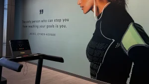 Treadmill with motivational quote on wall, highlighting best cardio exercises for achieving fitness goals.