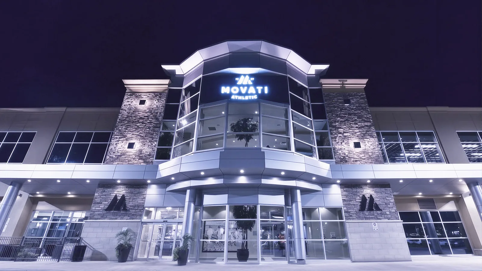 MOVATI Athletic building illuminated at night, marking the Guelph & Brantford Anniversary celebration.