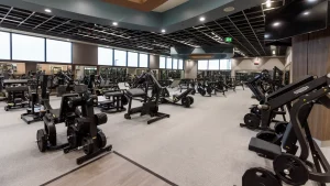 Spacious gym with various workout machines, illustrating different phases of training at MOVATI Athletic.