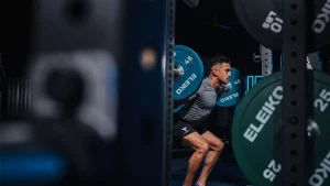 Man performing barbell squats in a gym, highlighting exercise trends 2026 with Eleiko weights.