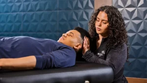 Fascial Stretch Therapy session with therapist assisting a relaxed client in improving mobility and flexibility.