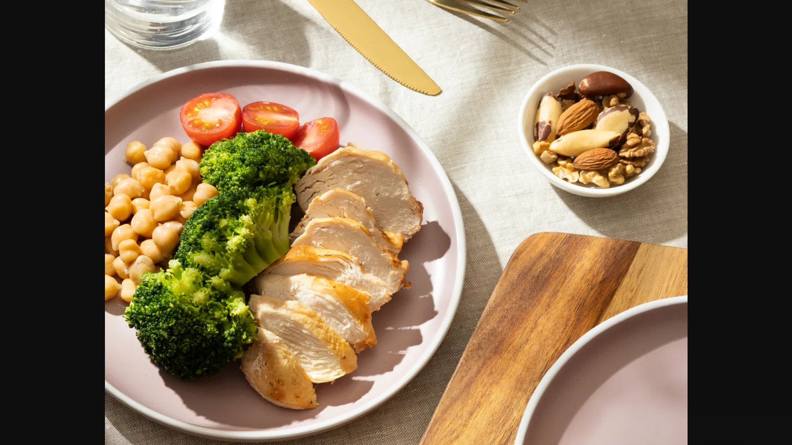 Plate with grilled chicken, broccoli, chickpeas, and tomatoes, highlighting heart healthy meal plans.