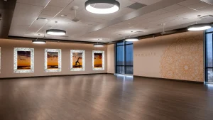 Spacious hot pilates studio with decorative wall art and wooden flooring, ideal for fitness and relaxation.