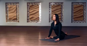 Person practicing yoga indoors, showcasing the latest yoga trends in a serene studio setting.