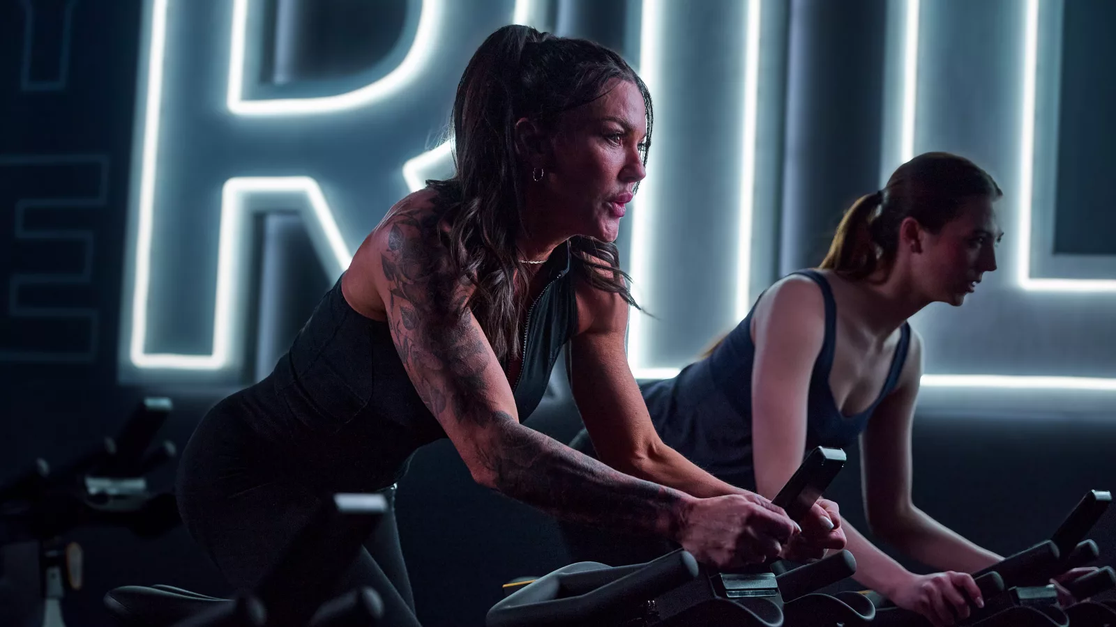 Women using high-tech stationary bikes showcase technology in workouts at a modern fitness studio.