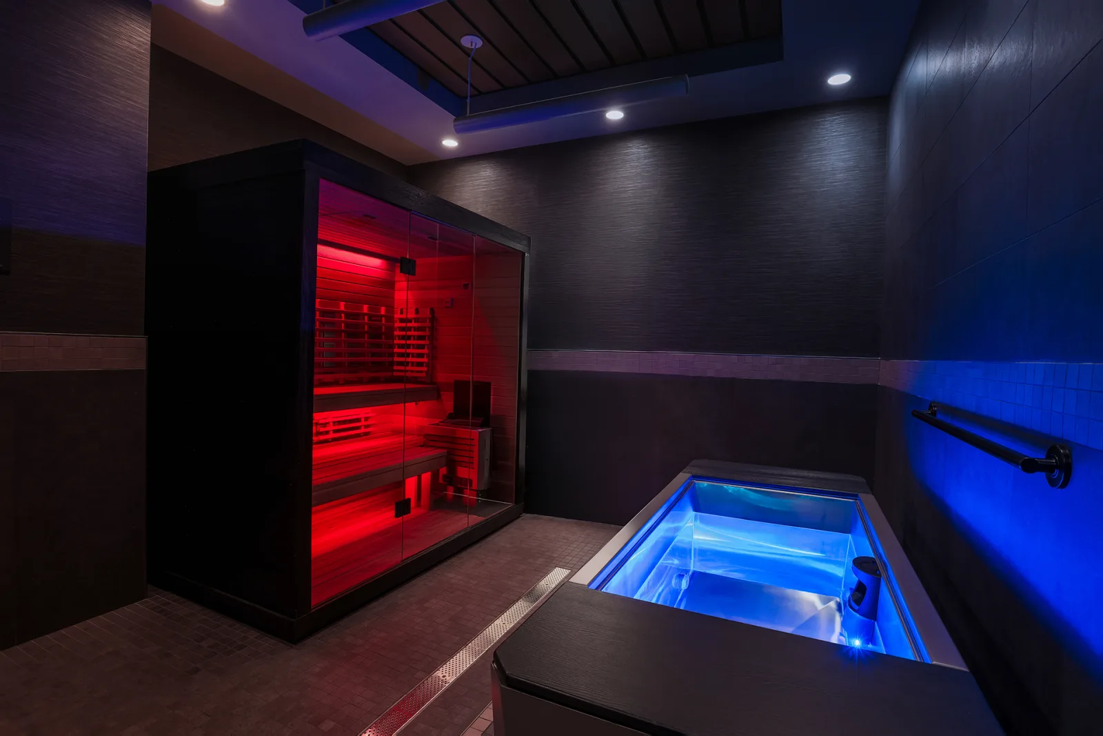 Modern spa room with illuminated cold plunge therapy pool and infrared sauna.